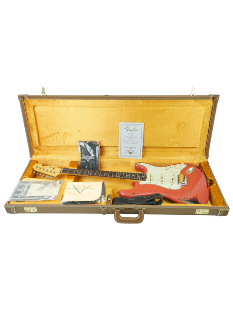 A red Fender Custom Shop '63 Michael Landau Stratocaster Relic guitar resting in its case, illustrating its iconic design and heritage.