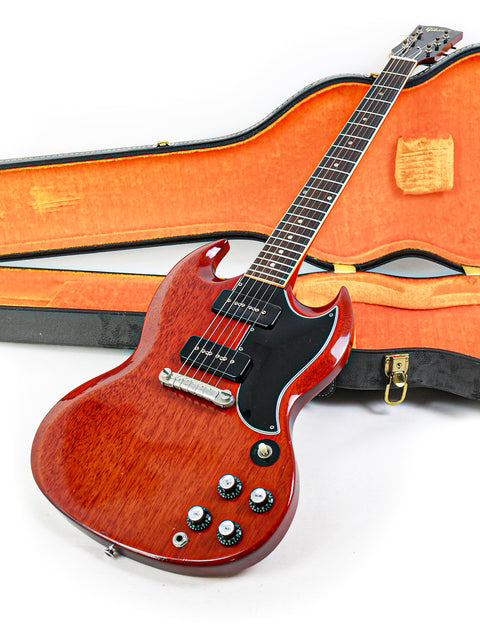 A red Gibson SG Special guitar from 1964/5, displayed in its case on the floor.