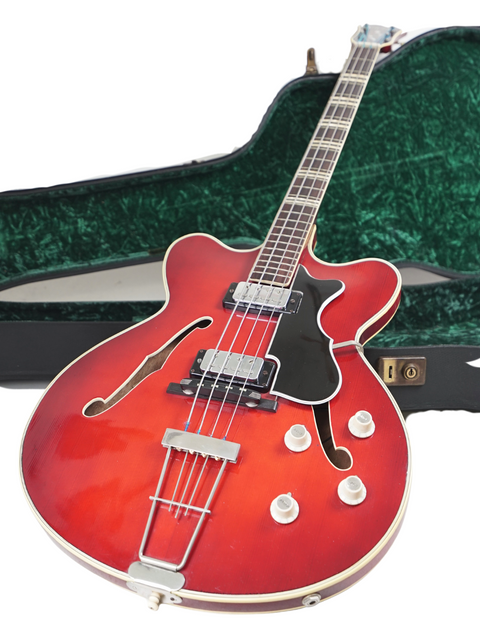 A red Hofner Verithin Bass guitar from 1961, elegantly displayed in a green case, highlighting its vintage appeal.