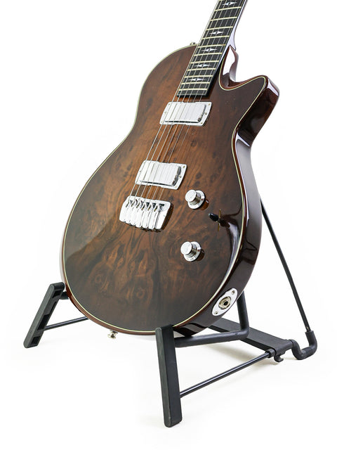 A sleek Taylor Solid Body guitar from 2007 on a stand, showcased with a simple white background.