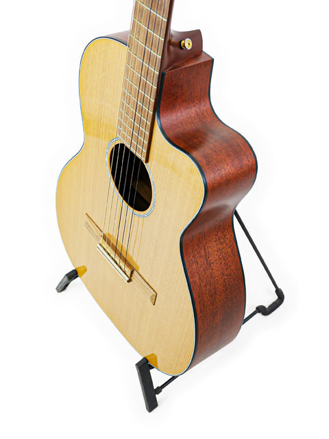 A small Martin 000C-16SGCTNE acoustic guitar from 2003 displayed on a stand, showcasing its elegant design and craftsmanship.