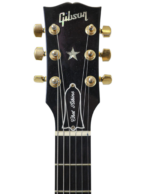 A striking black Gibson Les Paul Custom Shop guitar, highlighting its premium features, paired with a 2001 Chet Atkins SST model.