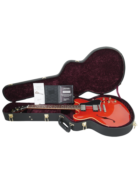 A striking red guitar case showcases a black Gibson Custom ES-335 Aged '59 Reissue guitar nestled within.
