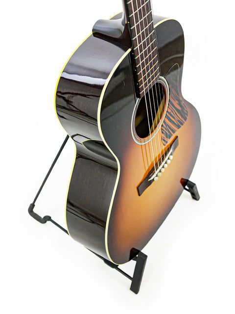 A sunburst acoustic guitar resting on a stand against a white backdrop.