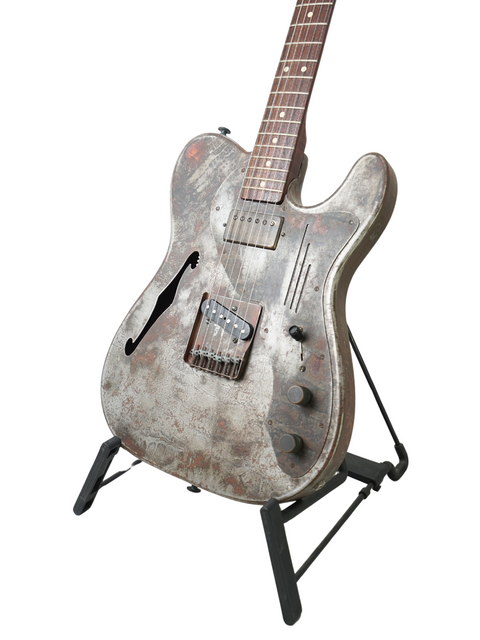 A vintage-style James Trussart Steelcaster guitar from 2006 resting on a stand, highlighting its rustic charm and artistry.