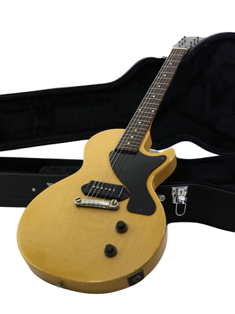 A vintage 1956 Gibson Les Paul Jr guitar in TV Yellow, housed in a case, set against a white background.