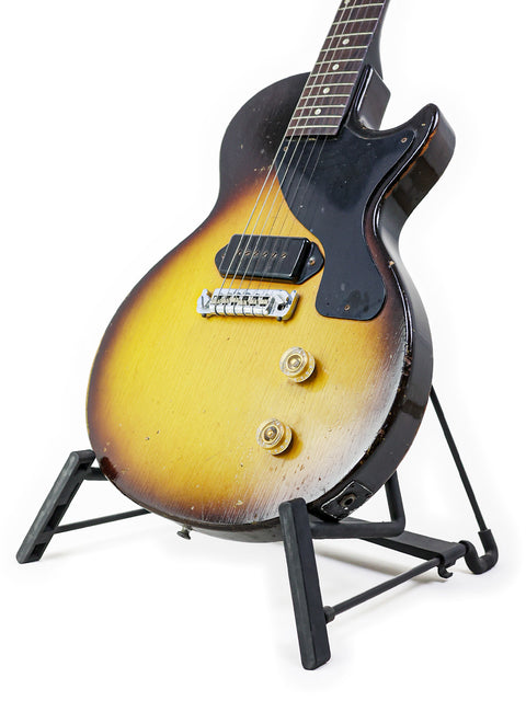 A vintage 1958 Gibson Les Paul Jr guitar in TV Yellow, resting on a stand, featuring a striking yellow and black finish.