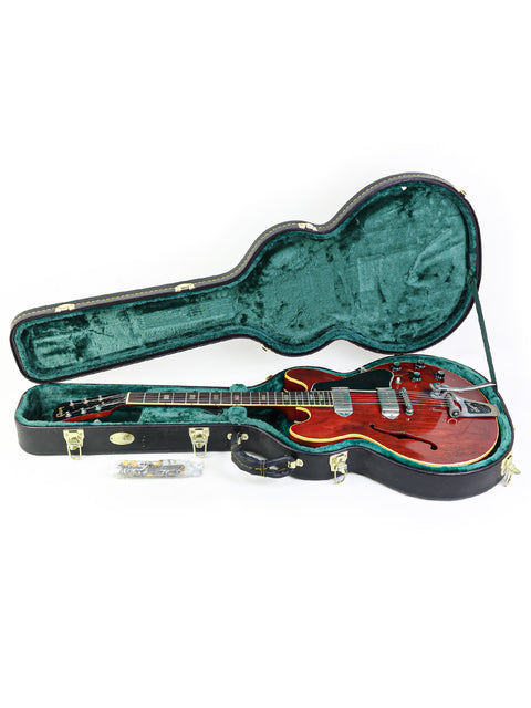 A vintage Gibson ES-330 guitar from 1965, red in color, securely placed in a green case for protection and style.