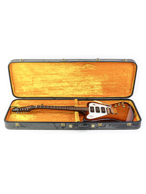 A vintage Gibson Non Reverse Firebird III guitar from 1966, displayed in a case on a white surface.