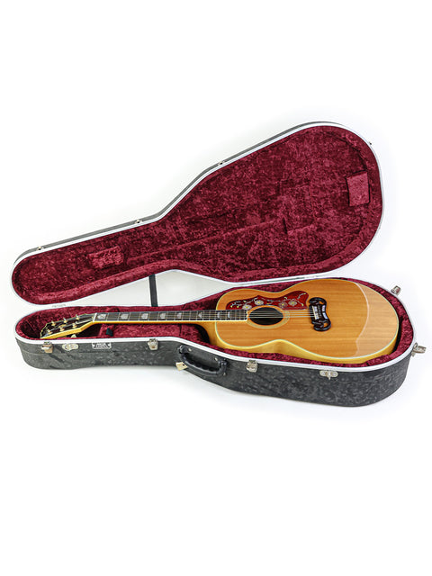 A vintage Gibson SJ-200 guitar case, elegantly lined with red velvet, highlighting its 1984 craftsmanship and style.