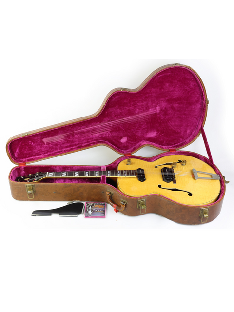 A vintage yellow Gibson ES-300 guitar from 1952, beautifully displayed in a pink case, merging nostalgia with flair.