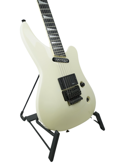 A white electric guitar on a stand, the Jackson Phil Collen Signature PC1 Archtop, an iconic USA model from 1989.