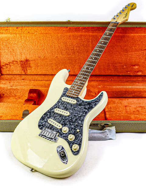 A white guitar, the Fender Jeff Beck Signature Stratocaster, nestled in a bright orange case.