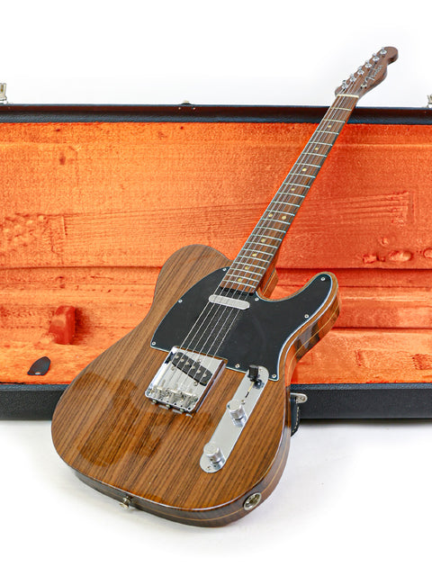  A wooden-bodied Fender Telecaster guitar rests in an orange case, part of the 2003 Masterbuilt John English limited edition.