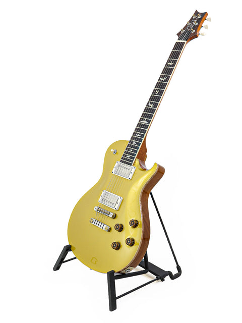 A yellow PRS McCarty Singlecut 594 electric guitar displayed on a stand, showcasing its vibrant color and sleek design.