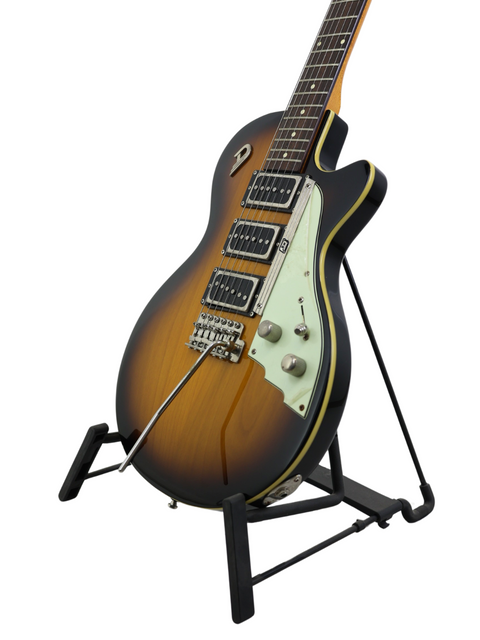An electric guitar with a sunburst finish resting on a black stand against a white background.