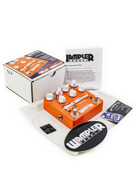 An orange pedal with a white sticker, representing the Wampler Brent Mason Hot-Wired Overdrive from 2012, USA.