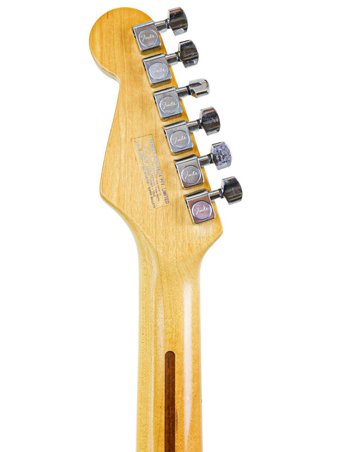 Back of a guitar neck with tuning pegs.