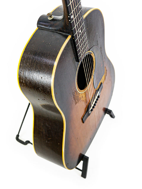 Beautiful wooden-bodied 1953 Gibson J-45 guitar showcased on a modern black stand.