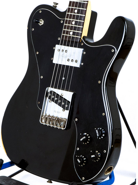 Black 1978 Fender Telecaster Custom guitar on a stand, featuring a rosewood fingerboard, exuding vintage charm.