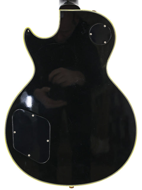 Black Gibson Custom Shop 1957 Les Paul Custom B3 guitar with a white pickguard, showcasing its classic design and elegance.
