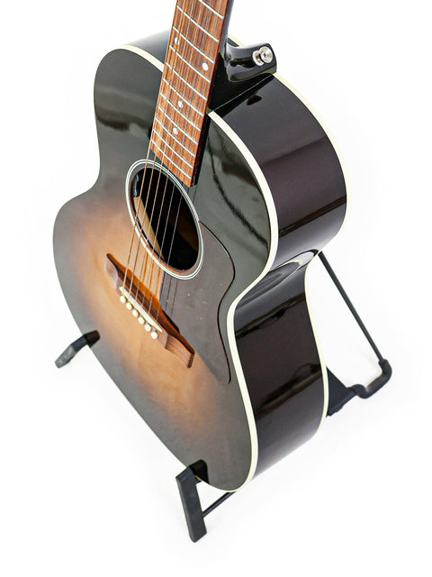 Black acoustic guitar on a stand, showcasing the Gibson L-00 Standard Vintage Sunburst from the USA, 2018 model.