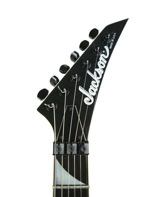 Black guitar with a white pickguard, representing the Jackson Phil Collen Signature PC1 Archtop model from 1989.