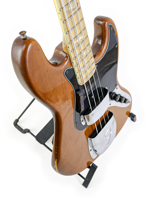 Brown 1974 Fender Jazz Bass guitar on a stand, highlighting its vintage appeal and iconic style.