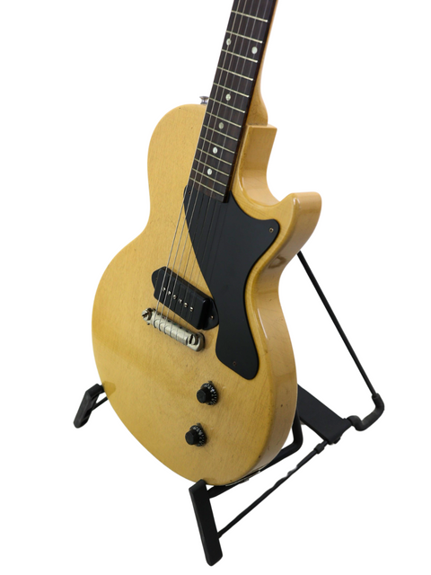 Classic 1956 Gibson Les Paul Jr TV Yellow guitar on a stand, set against a simple white background for emphasis.