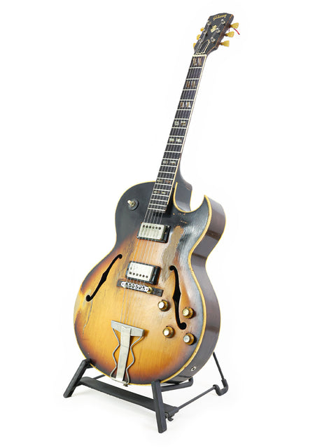 Classic 1962 Vintage Gibson ES-175D guitar resting on a stand, set against a bright white background for a striking look.