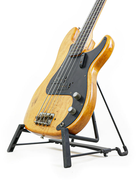 Classic 1963 Fender L-Series Precision Bass guitar on a stand, featuring a striking white background for a clean look.