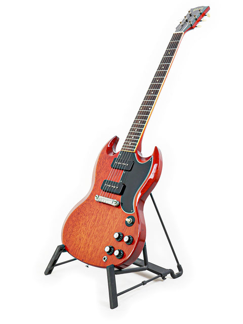Classic 1964/5 Gibson SG Special guitar elegantly positioned on a stand with a simple white backdrop.