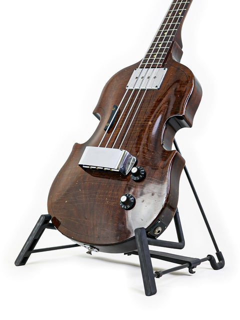 Classic 1969 Gibson EB-1 guitar resting on a stand, highlighted by a pristine white background.
