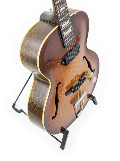 Classic Vintage Gibson ES-125 guitar on a stand, highlighting its timeless beauty against a white background.