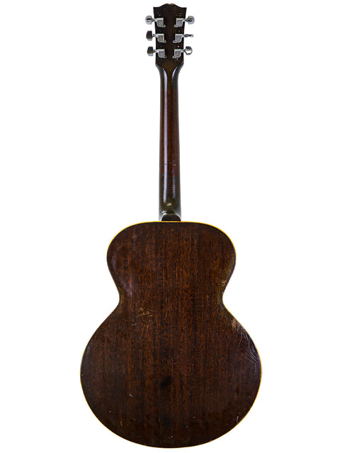 Close-up of a 1930s Gibson J-45 guitar, highlighting its beautiful mahogany back and vintage charm.
