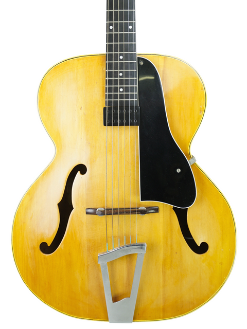 Close-up of a 1951 Gibson J-45 sunburst guitar, highlighting its vintage charm next to a 1940 Vega C-66 model.