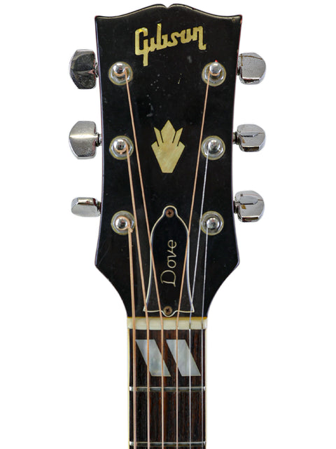 Close-up of a 1968 Gibson Dove guitar headstock showcasing the Gibson name.
