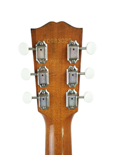 Close-up of a 2013 Gibson J-35 acoustic guitar headstock, showcasing four knobs for tuning and sound control.