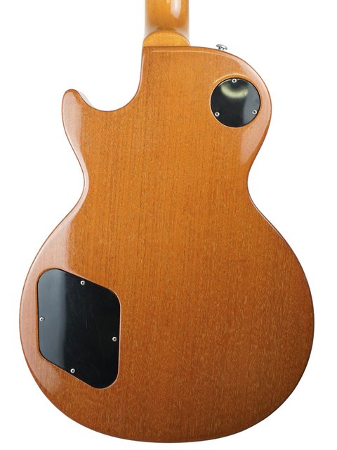 Close-up of a Gibson Les Paul Deluxe guitar featuring a wooden body and black headstock, commemorating its 30th Anniversary.