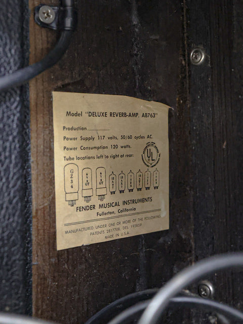 Close-up of a label on a wooden cabinet reading "Vintage Fender Deluxe Reverb Blackface Combo – USA 1967."