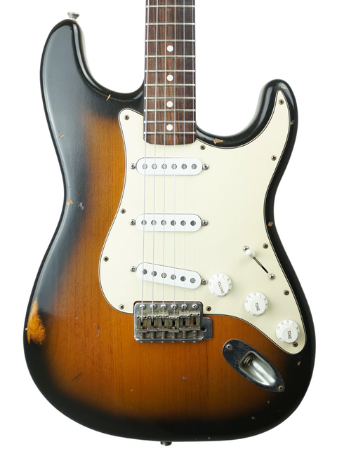 Close-up of a sunburst Fender Custom Shop 1964 Stratocaster, highlighting its relic features and classic craftsmanship.
