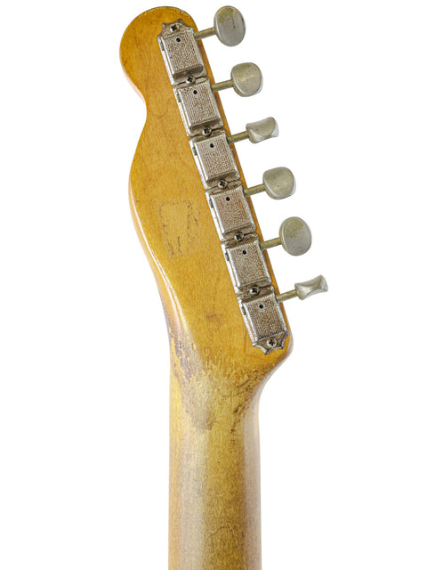 Close-up of a vintage 1963 Fender Telecaster headstock, showcasing its wooden body and classic design details.