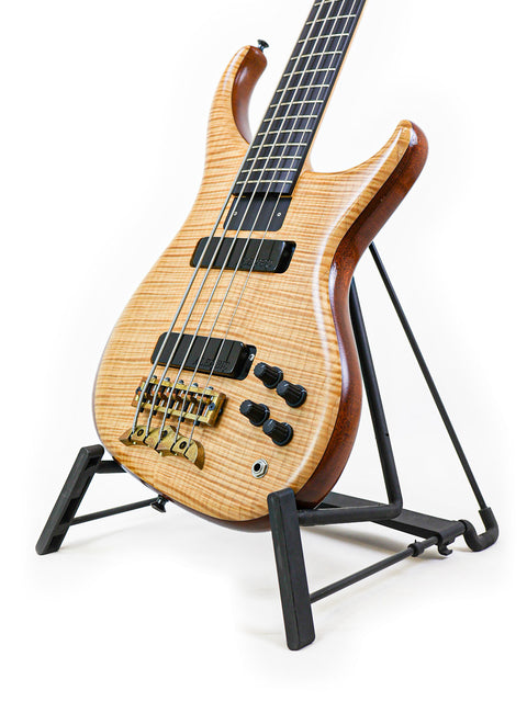 Close-up of the body of the Alembic Orion bass guitar, focusing on the dual pickups, bridge, and control knobs.
