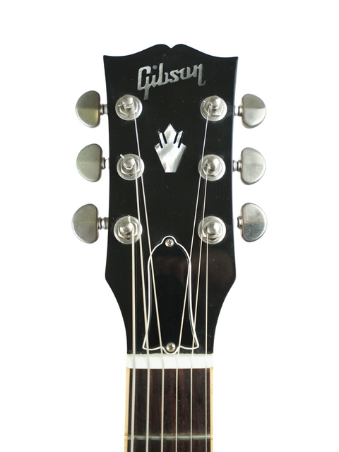 Close-up of the headstock from a 2006 Gibson ES-335 Dot, illustrating the guitar's distinctive style and premium build quality.

