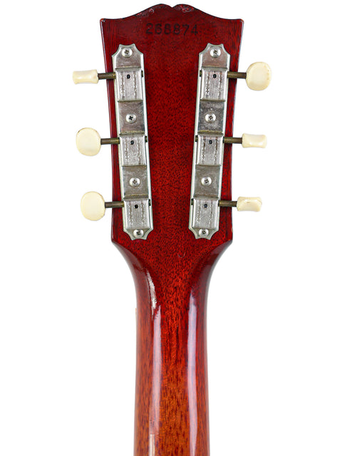 Close-up of the headstock of a 1964/5 vintage Gibson SG Special electric guitar featuring a vibrant red finish.