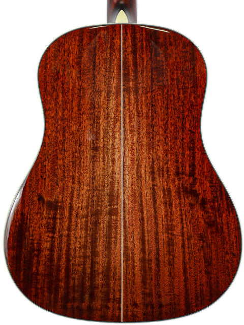 Close-up of the textured wood back of an acoustic guitar.