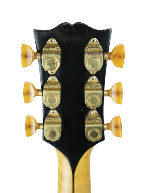 Close-up shot of the headstock from a 1939 Gibson L-5 electric guitar, emphasizing its vintage charm and intricate details.