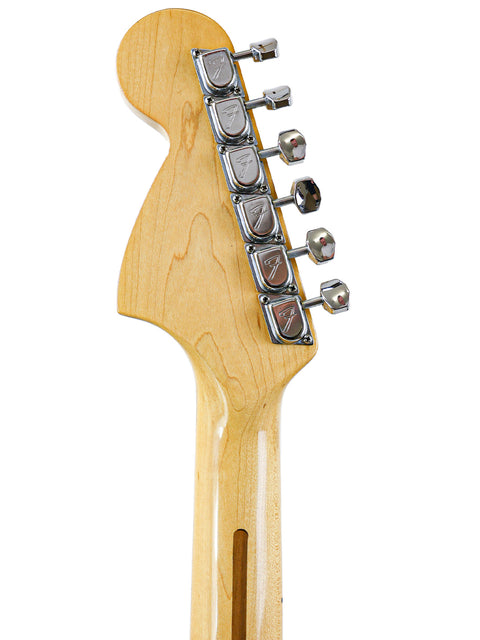 Detailed view of a 1977 USA Fender Stratocaster guitar head, set against a bright white background, highlighting its vintage charm.