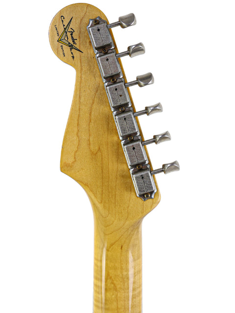  Detailed view of a Fender Custom Shop 1961 Stratocaster head, highlighting the wooden body and vibrant Dakota Red color.