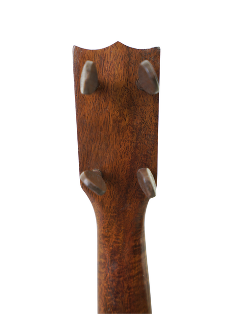 Detailed view of a wooden guitar head from a vintage Kumalae Model D ukulele, highlighting its craftsmanship from Hawaii, c. 1920.